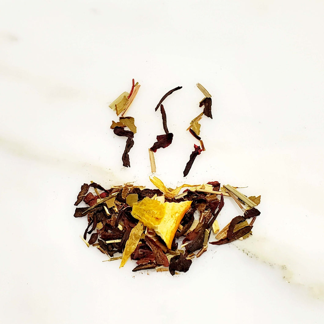 Tea cup-shaped leaves of a tea blend featuring mixture of Green Rooibos, Hibiscus, Dried orange Pieces, for our hydrating Cran-Lemon Ice Tea